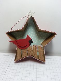 an ornament shaped like a star with a red bird perched on the top