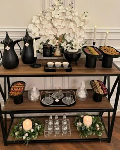 a buffet table filled with desserts and drinks on it's side, surrounded by white flowers