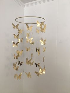 a wind chime with gold butterflies hanging from it's sides in a room