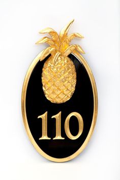 a black and gold plaque with a pineapple on it's side that reads 10