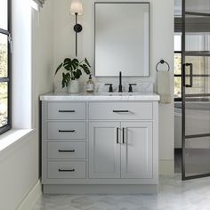 a bathroom with two sinks and a mirror on the wall next to a large window