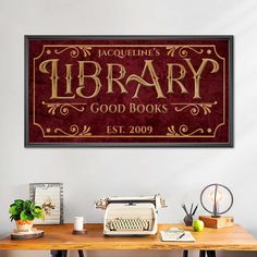 a wooden table topped with a typewriter next to a wall mounted sign that says library