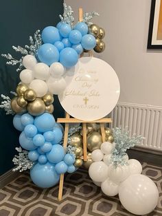 a balloon arch with blue, white and gold balloons