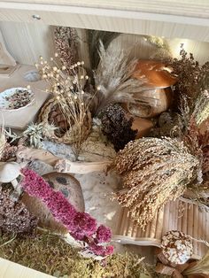 an assortment of dried flowers and plants in a wooden box