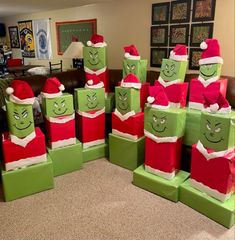 several green and red boxes with faces on them in the shape of santa's hats