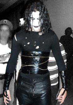 a man dressed in black leather with his face painted white