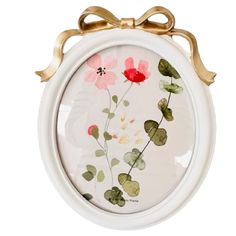 a white and gold frame with flowers painted on the glass in it's center