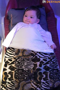 a small child laying on top of a bed in a room with purple walls and flooring