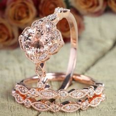 two rose gold wedding rings set with an oval cut diamond center surrounded by smaller pink and white diamonds