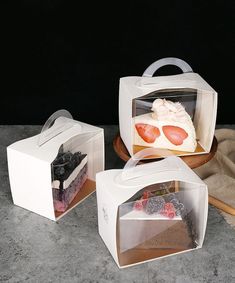 three different types of cakes in boxes on a table