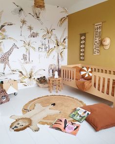 a baby's room with giraffes and zebras on the wall