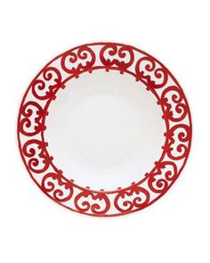 a red and white plate with an ornate design on the rim, against a white background