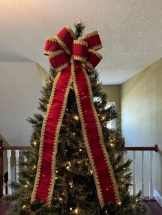 a decorated christmas tree with red and gold ribbon