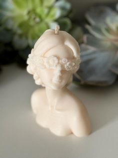 a small white figurine sitting on top of a table