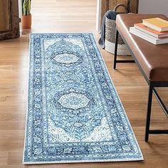 a large blue rug is in the middle of a room with a bench and chair