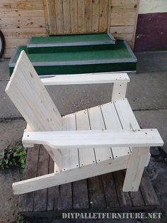 a wooden chair sitting on top of a wooden floor next to a green table and bench