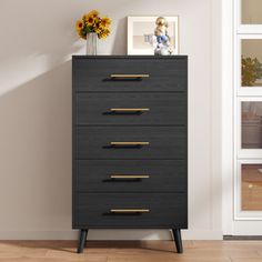 a black chest of drawers with gold handles and knobs in a white living room