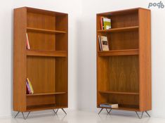 two wooden bookshelves sitting next to each other on top of a white floor