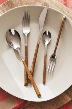 a white plate topped with silverware and wooden utensils