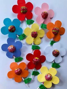 colorful paper flowers with candy on them are arranged in the shape of an easter egg