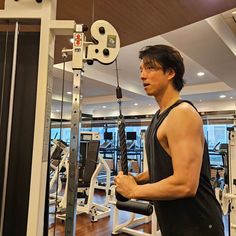 a man standing next to a machine in a gym