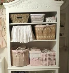 a white bookcase with baskets on top of it next to a bed and dresser