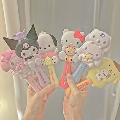 someone holding up hello kitty erasers in their hands