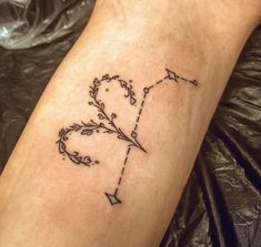 a tattoo on the leg of a woman with an arrow and heart in it's center