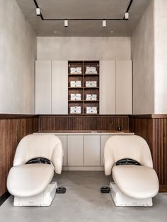 two white recliners sitting in the middle of a room next to a counter