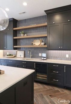 a kitchen with black cabinets and white counter tops