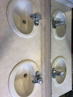 two white sinks sitting next to each other in a bathroom under a wall mounted mirror