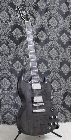 an electric guitar sitting on top of a table next to a wallpapered background