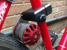 a close up of a bike with red spokes and black brake pads on it