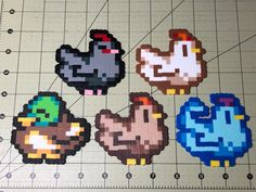 four pixelated chicken stickers on a cutting board with rulers next to them