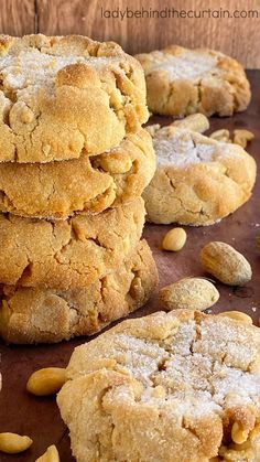 a pile of cookies sitting on top of a wooden table next to some almonds