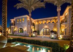 a large house with palm trees in front of it and water feature at the bottom