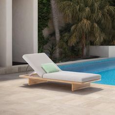 a pool with a lounge chair next to it and palm trees in the back ground