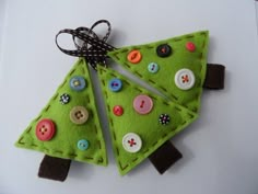 two felt christmas trees with buttons on them