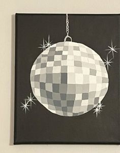 a black and white christmas ornament hanging on a wall with stars around it