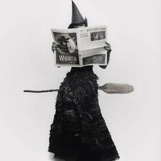 a person wearing a witch hat and holding a newspaper