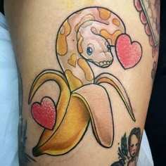 a close up of a tattoo on a person's leg with a banana and heart