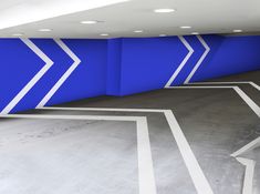 an empty parking garage with blue and white painted walls