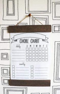 a wall hanging with a chore chart attached to it's side, on a white wall