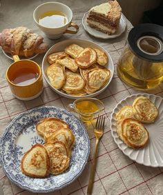 a table topped with plates and cups filled with food