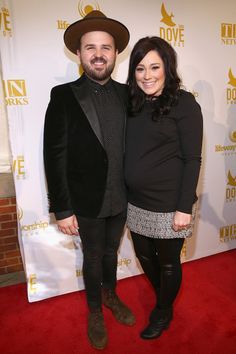 a man and woman standing next to each other on a red carpet