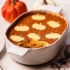 a cake in a pan with pumpkins on the side