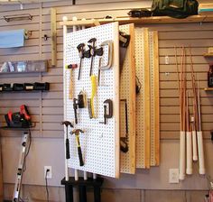 the tools are hanging on the wall in the garage with pegs and wrenches