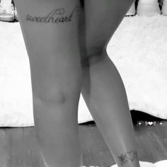 black and white photograph of woman's legs with words tattooed on her lower leg