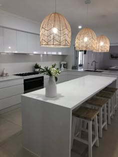 a kitchen with white counters and stools in it