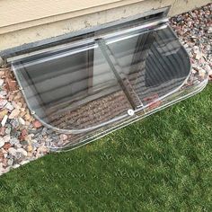 an open window on the side of a house with rocks and gravel around it in front of a door